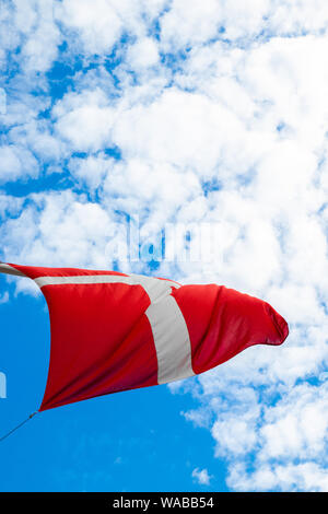Flag of Denmark, Dannebrog against the blue sky develops in the wind
