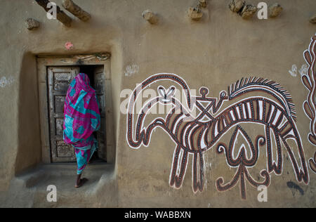 Tribal woman entering her house + Sohrai art ( India) Stock Photo