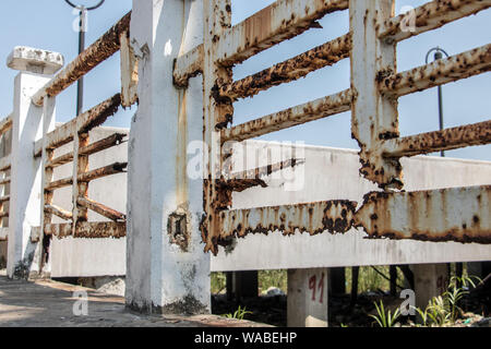 Rusting railing at the pier. Corrosion on white railing, close up view. Stock Photo
