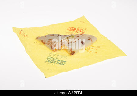 McDonald’s grilled ranch chicken snack wrap cut in half on wrapper showing chicken, shredded cheese & lettuce on flour tortilla