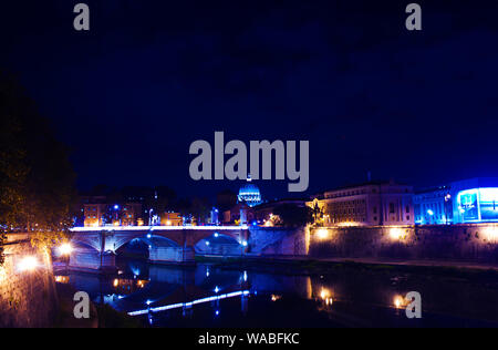 Image of Rione Ponte district. View of white Ponte Vittorio Emanuele II bridge and its reflection, orange trees, waters of Tiber river under dark blue Stock Photo