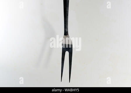 Stainless steel meat fork is very useful in the kitchen for frying and turning meat Stock Photo
