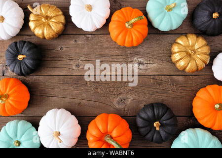 Autumn frame of various colorful pumpkins on a rustic wood background. Top view with copy space. Stock Photo