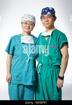 (190819) -- BEIJING, Aug. 19, 2019 (Xinhua) -- Xu Xiequn (R), associate chief physician of general surgery department, and his wife Wang Jinhui, associate chief physician of gynaecology and obstetrics department, pose for a photo at their work place of the Peking Union Medical College Hospital in Beijing, capital of China, Aug. 16, 2019. China has about 3.6 million qualified physicians and 4.1 million registered nurses. They have formed a strong force to support the most significant medical service system in the world of safeguarding the health of 1.4 billion people in the country.    China de Stock Photo