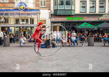 AMSTERDAM, NETHERLANDS - SEPTEMBER 1, 2018: Street performer entertains crowd on urban street in the city of Amsterdam. Stock Photo