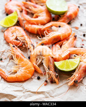 Shrimps served with lemons and spices on a paper background Stock Photo