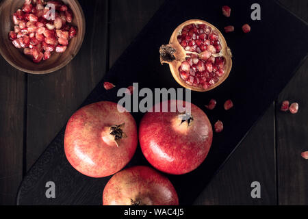 Pomegranate on cutting board. Dark food. Close up. Punica granatum Stock Photo