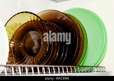 Dish dryer in the closet. White background. Plates of different colors. Cleaning, cleanliness Stock Photo