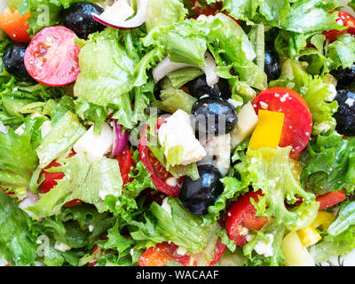 food background - greek salad from fresh vegetables , feta cheese and black olives dressed by olive oil close-up Stock Photo