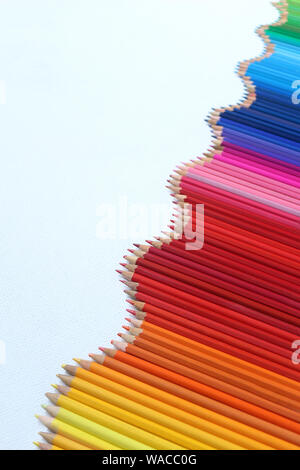 An undulating line of coloured pencils on a white background Stock Photo