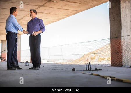 Two executives discuss plans on construction site. Stock Photo