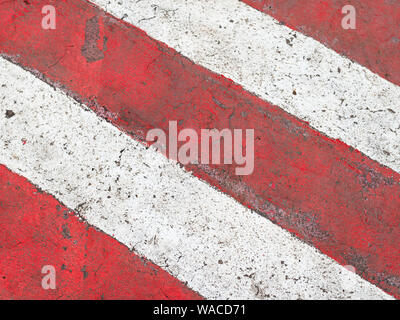 urban background - red and white stripes on asphalt road in parking prohibition zone Stock Photo
