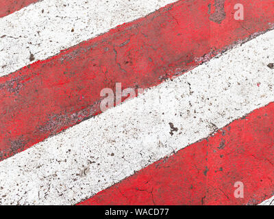 urban background - painted red and white stripes on asphalt road in parking ban zone Stock Photo