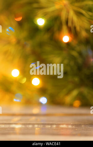 Blurred background of a Christmas tree with burning lights. Yellow flare on the right, vertical frame Stock Photo