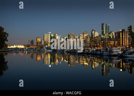 Coal Harbor Skyline Twilight Reflections. A calm Coal Harbor next to Stanley Park at twilight. Vancouver, British Columbia. Stock Photo