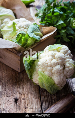 Fresh organic homegrown cauliflower in wooden crate, vegan meal, plant based food, close up, selective focus Stock Photo