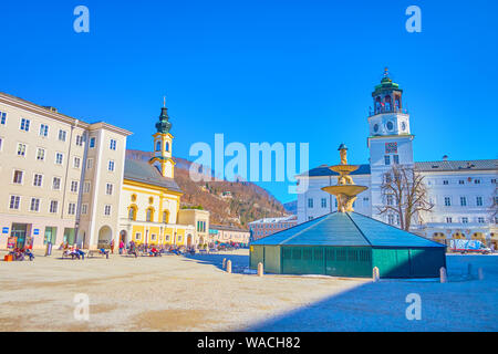 SALZBURG, AUSTRIA - FEBRUARY 27, 2019: The central Residenzplatz square with winter cover of Residenzbrunnen fountain and the New Residence Palace of