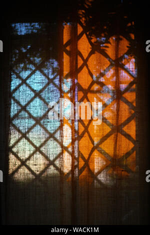 Curtains on the window, on which falls the shadow of the lattice Stock Photo