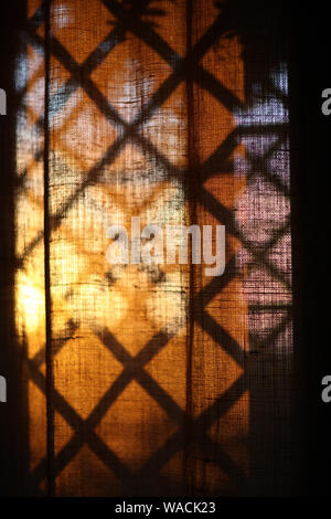 Curtains on the window, on which falls the shadow of the lattice Stock Photo