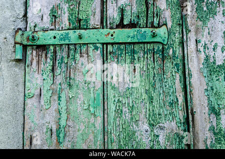 Old green painted wood door for background. Vintage background from a wooden shabby plank with metal lock. Wood texture. Background old panels. Copy s Stock Photo
