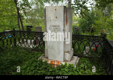 Grave of Russian Bolshevik revolutionary Pyotr Yermakov (1884 - 1952) at Ivanovskoye Cemetery in Yekaterinburg, Russia. He is notable as one of the persons responsible for the execution of the Romanov family in Yekaterinburg in July 1918, including the deposed Tsar Nicholas II, his wife, their children, and their retinue. According to his own memories, he personally killed Tsar Nicholas II and his wife. The gravestone was vandalized by the symbolical bullet holes and bloody red paint in the 1980s. Stock Photo