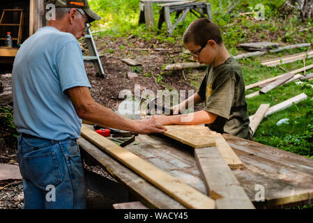 Two people work together to build a storage shed in do-it-yourself project at home. Stock Photo