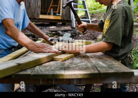 Two people work together to build a storage shed in do-it-yourself project at home. Stock Photo