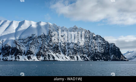 snowy mountains shaped wave under a blue sky Stock Photo