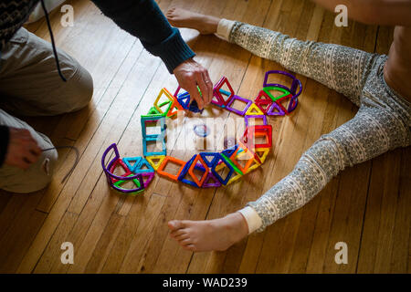 A father and child play spinning tops in a hand-constructed arena Stock Photo