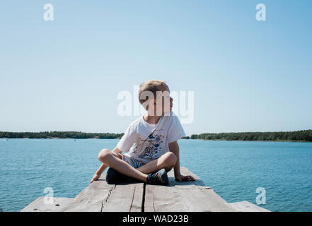 portrait of a young boy looking out to sea on holiday in summer Stock Photo