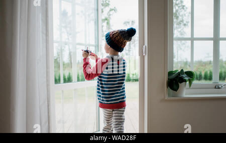 young boy playing with an aeroplane at home Stock Photo