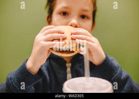 Boy eating burger at restaurant Stock Photo