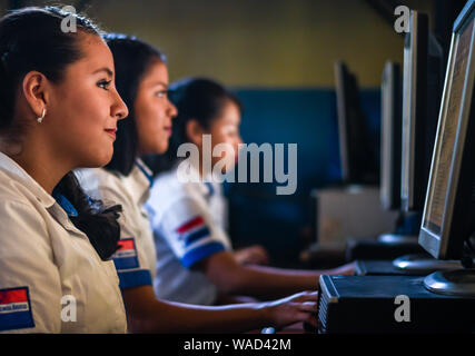 latin female students working on computers at college in Guatemala Stock Photo