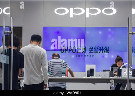 --FILE--Customers shop at a store of Chinese smartphone maker OPPO on the Nanjing Road pedestrian shopping street in Shanghai, China, 27 June 2019. Stock Photo