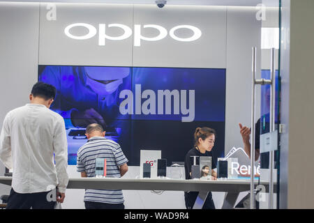 --FILE--Customers shop at a store of Chinese smartphone maker OPPO on the Nanjing Road pedestrian shopping street in Shanghai, China, 27 June 2019. Stock Photo