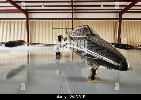 Private black 1970's vintage Lear Jet, parked in an airport hanger, at Bessemer Airport, Bessemer Alabama, USA. Stock Photo