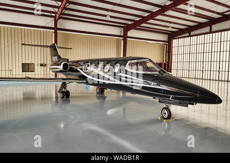 Private black 1970's vintage Lear Jet, parked in an airport hanger, at Bessemer Airport, Bessemer Alabama, USA. Stock Photo