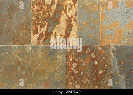 Rust colored square flagstones on a wall. Texture detail close up. Stock Photo