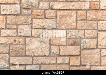 Untreated stone wall, pattern of square stones. Texture detail. Stock Photo
