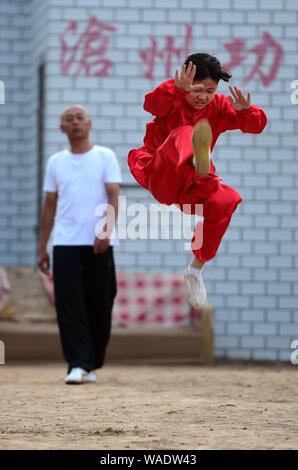 A Chinese child practices Chinese martial arts or kungfu directed by Chen Honglin, a well-known local practitioner, to maintain fitness during the sum Stock Photo