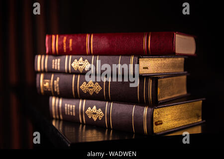 Old books stacked on a wooden table Stock Photo