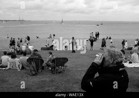 Spectators during Cowes Week on The Green at Cowes seafront Cowes Isle of Wight Stock Photo