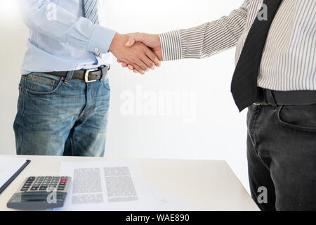 young man shaking hands with an insurance agent or investment adviser  realtor after signing contract document accept agreement making purchase deal i Stock Photo