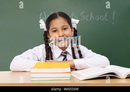 Schoolgirl holding pencil in her mouth Stock Photo - Alamy