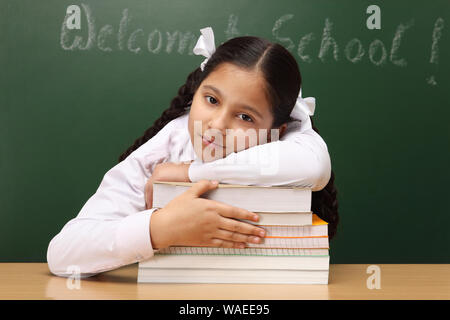 Schoolgirl looking tired while studying Stock Photo