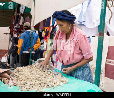 Local indigenous Mexican people woman vendor in traditional dress selling copal resin for incense in village market, Tlacaloula, Oaxaca, Mexico Stock Photo