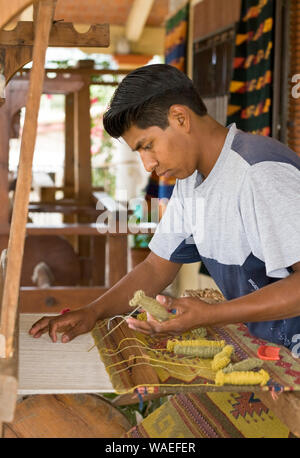 Mexican indigenous people artisan man weaving traditional Zapotec style rug, Teotitlan del Valle, Oaxaca, Mexico local handicrafts Stock Photo