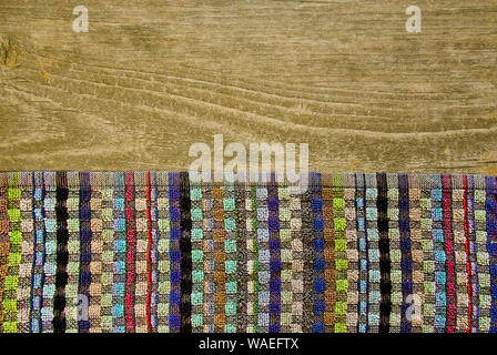 Plan view of a colorful towel laying on a ground of wood with texture Stock Photo