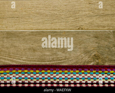 Plan view of a colorful towel laying on a ground of wood with texture Stock Photo