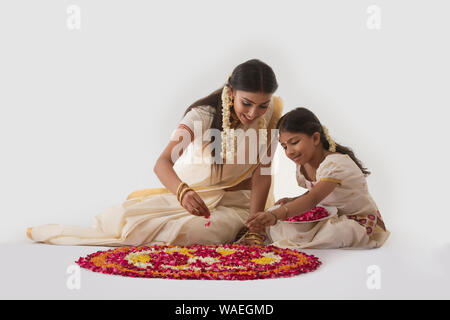 south indian woman making rangoli with her daughter Stock Photo